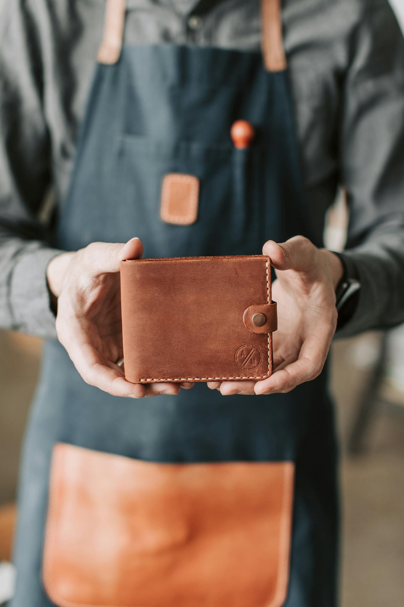 a craftsman holding a handmade leather wallet